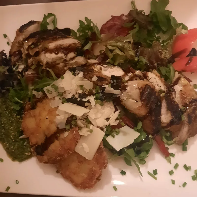 Assiette dorée avec roquette, copeaux de parmesan et pesto